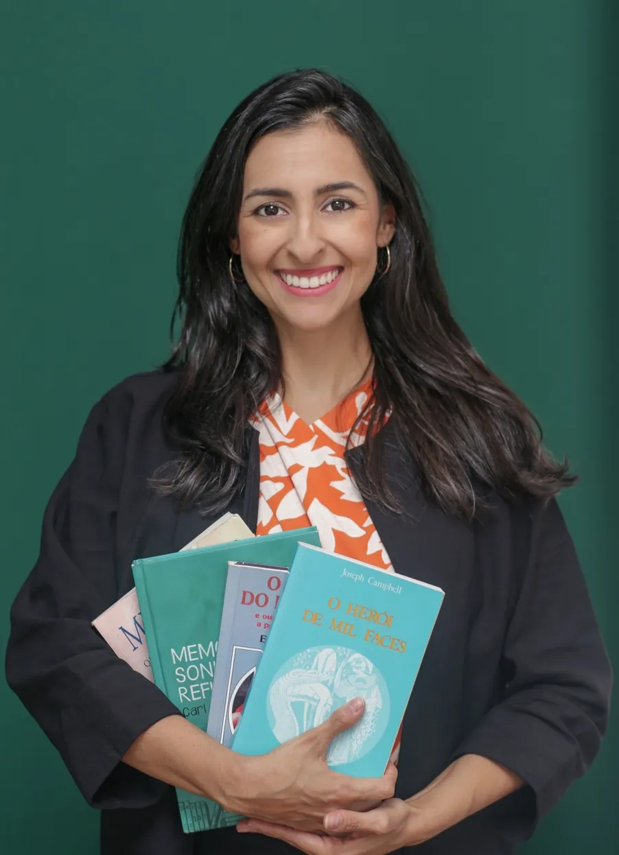 Natália Pozzatto com livros de psicologia no consultório